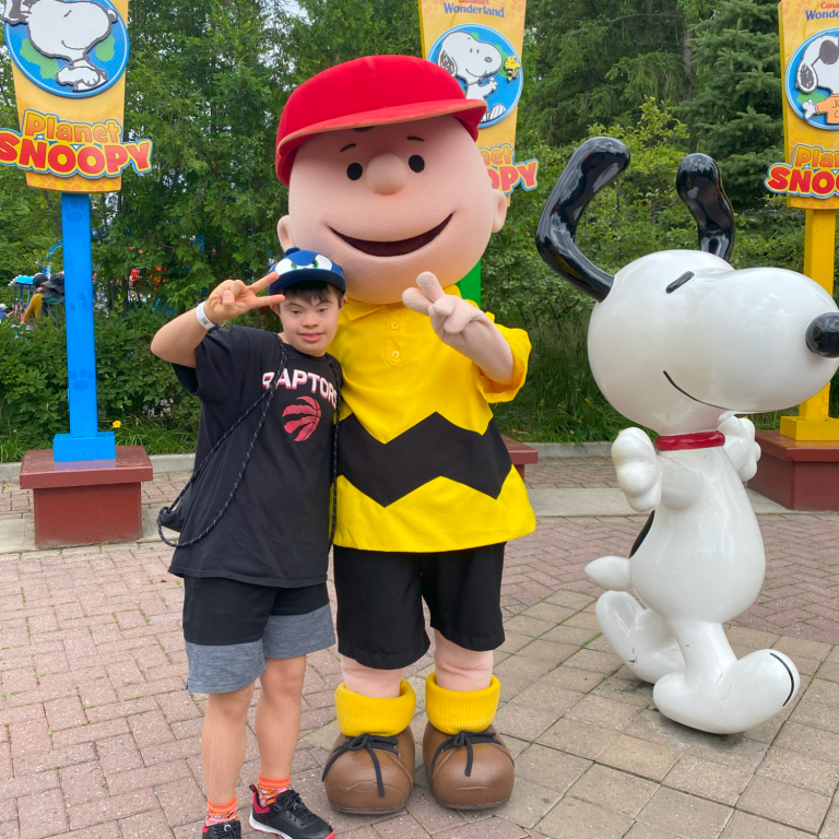 Boy standing beside a Charlie Brown character found in Canada's Wonderland