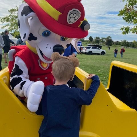 Fire fighting dog with kid saying hi
